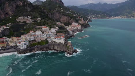 hotels and restaurants perched on rugged cliff overlooking the tyrrhenian sea in amalfi coast, italy