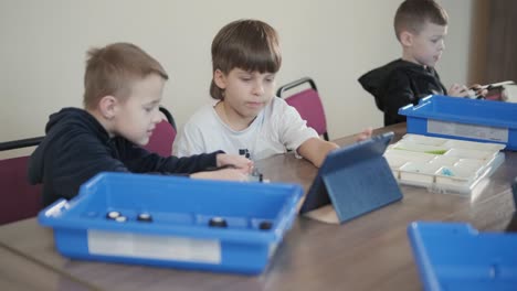 children engage in stem learning activities, assembling robotics kits with focus and teamwork in a classroom setting