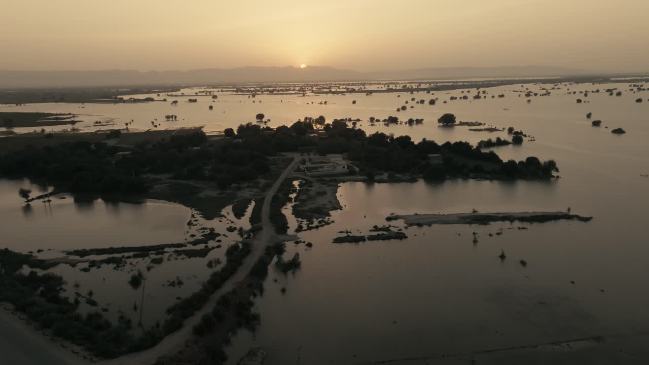 Wide angle drone view of sunset over water logged field due to heavy flood in Punjab, Pakistan