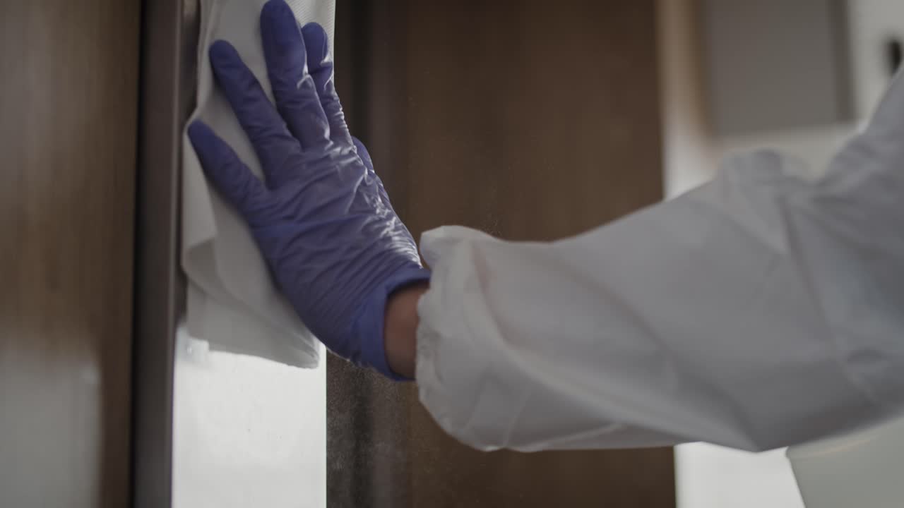 Handyvideo von Händen, die Aufzugknöpfe desinfizieren.