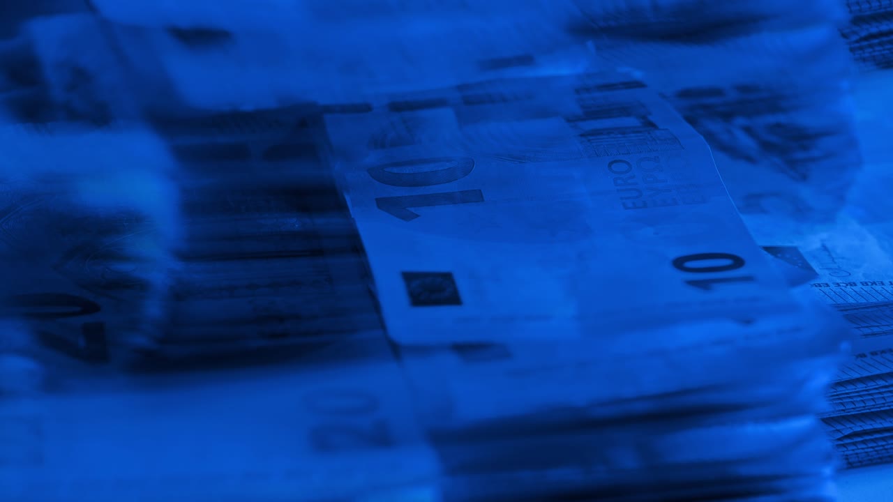 Pilha de dinheiro banhada em tons de azul sugere distanciamento do valor emocional