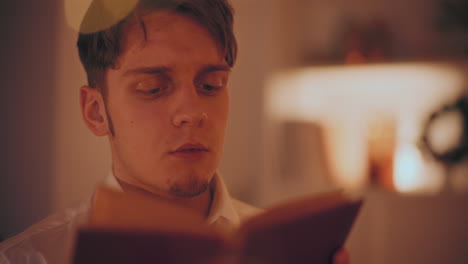primer plano de un hombre leyendo un libro en casa durante la navidad