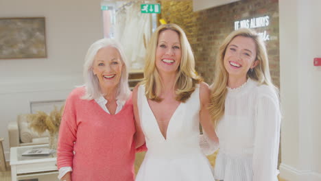 Portrait-Of-Grandmother-With-Adult-Daughter-And-Granddaughter-Trying-On-Wedding-Dress-In-Store