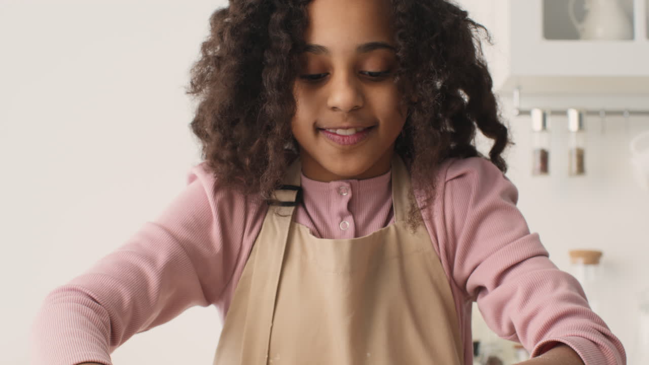 una chica joven horneando en la cocina.