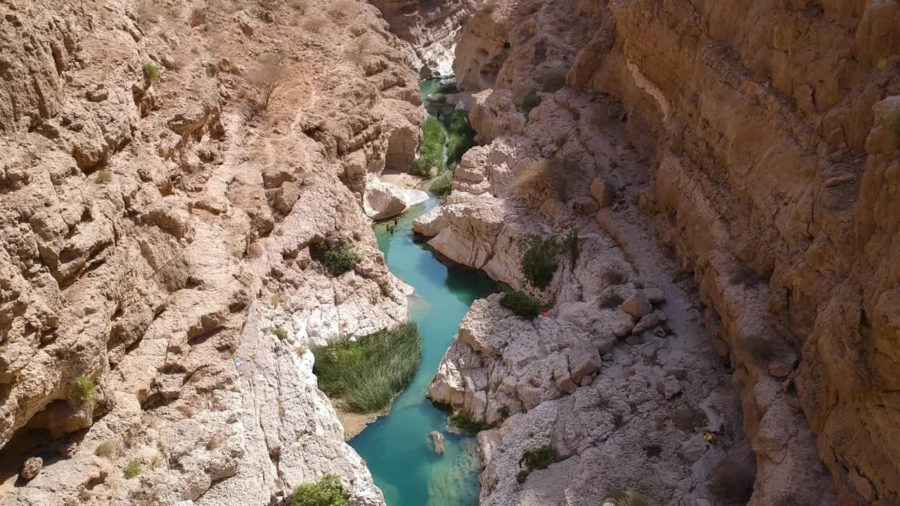 Aerial of stunning Wadi Tiwi oasis with turquoise water and canyon in the Sultanate of Oman