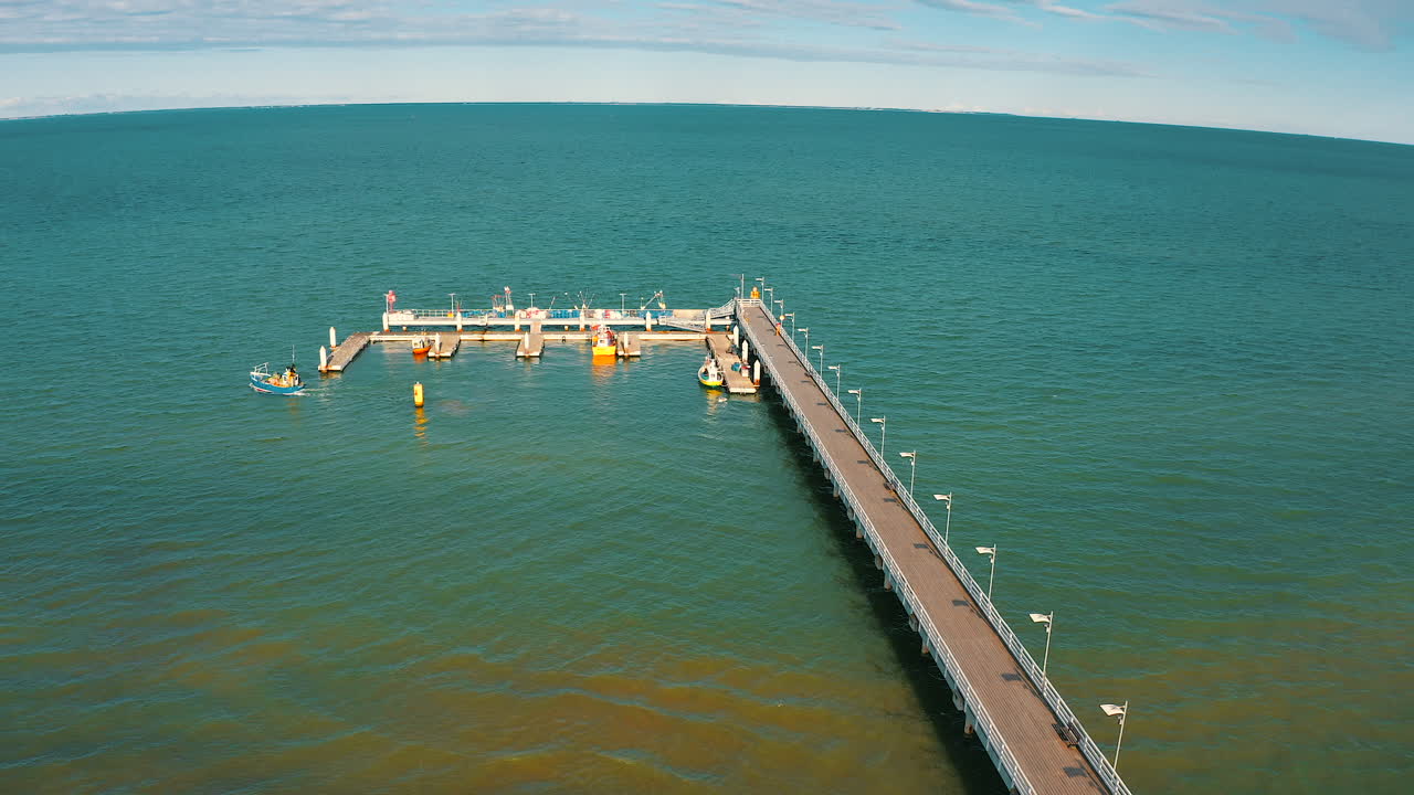 vista aérea de un barco de pesca que se acerca al muelle en el mar