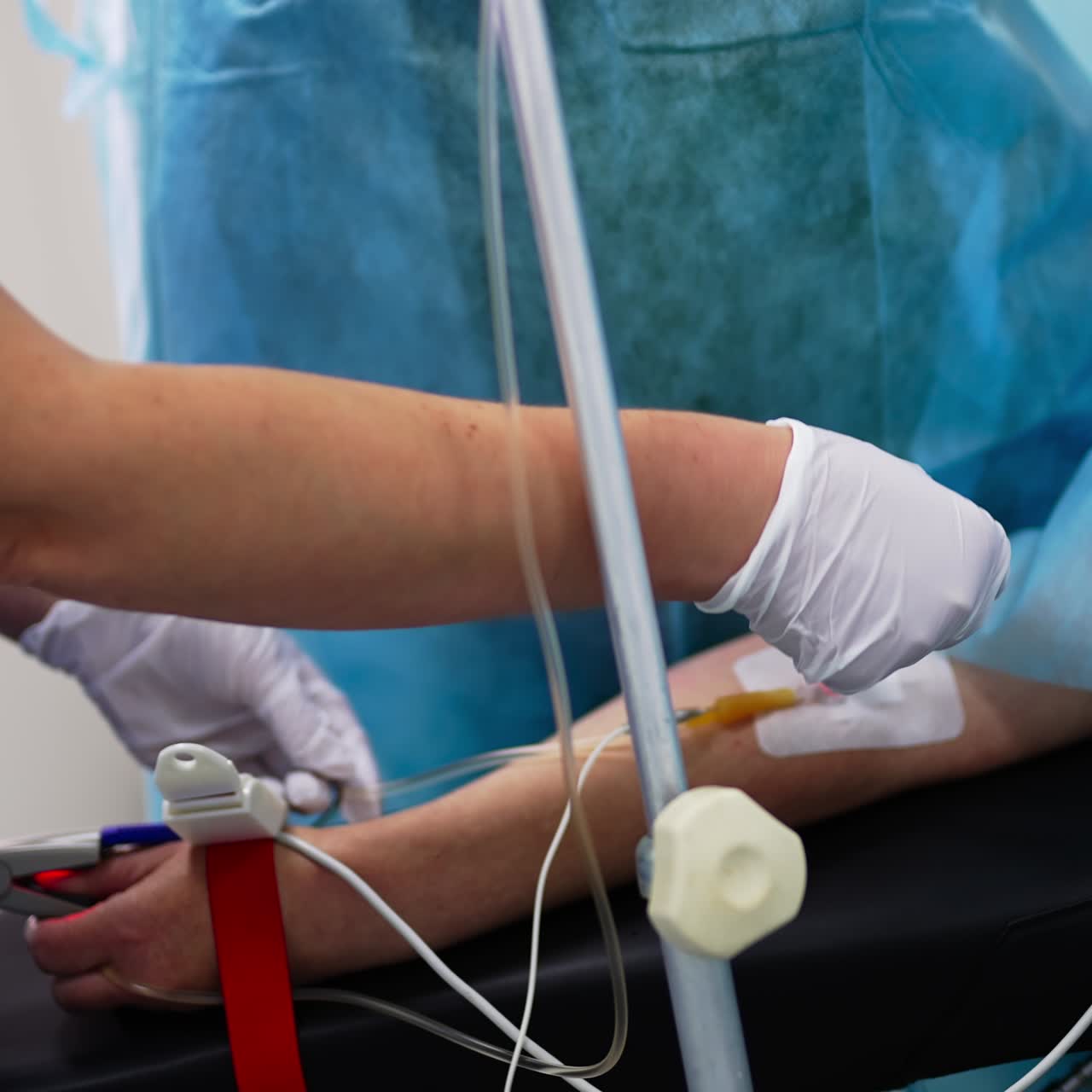 Connecting the patient to the equipment in surgery room. Nurse making injection to a person prepared for operation