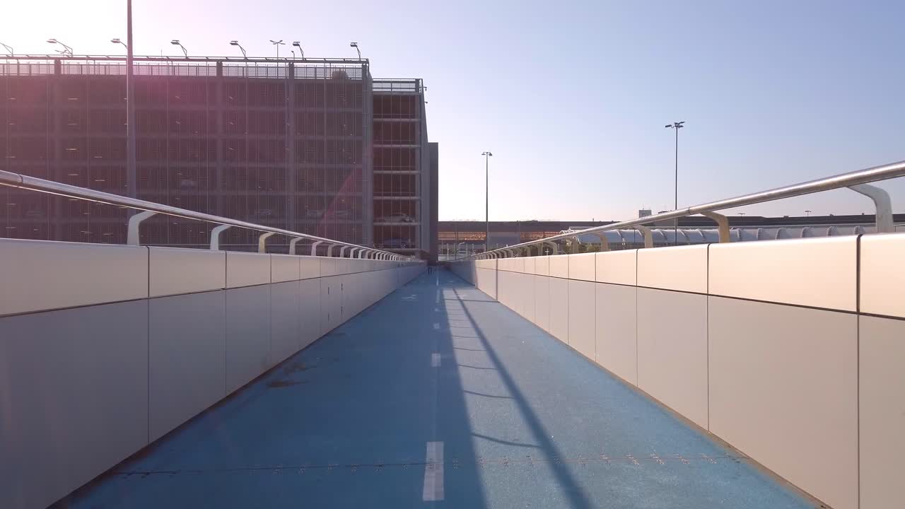 Handheld walking shot of footbridge to Sydney Kingsford Smith International Airport during Coronavirus pandemic in a sunny day. Sydney, Australia