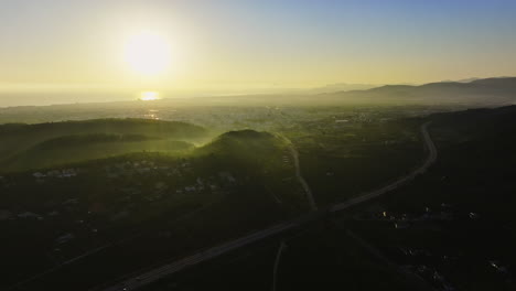 amanecer sobre una ciudad costera y montañas desde una perspectiva aérea