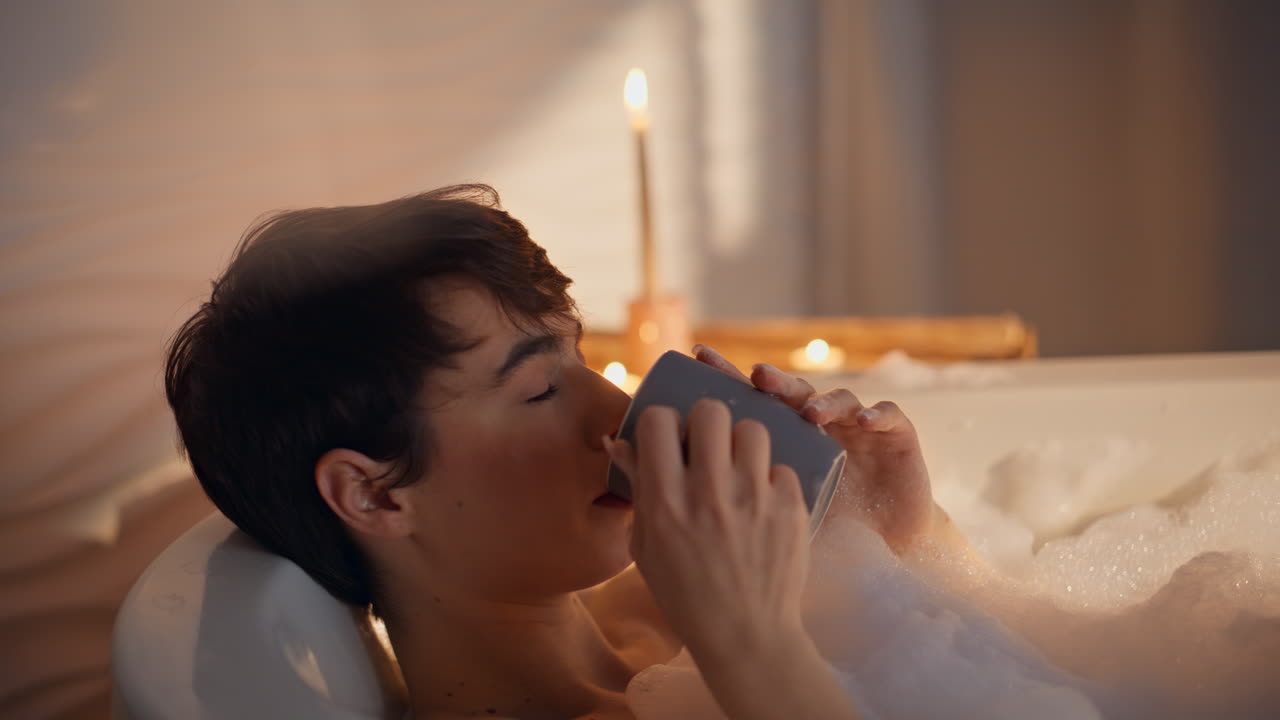Nærbilde av kvinneben under spa-behandling. Nydelig millennial-jente nipper til varm te.