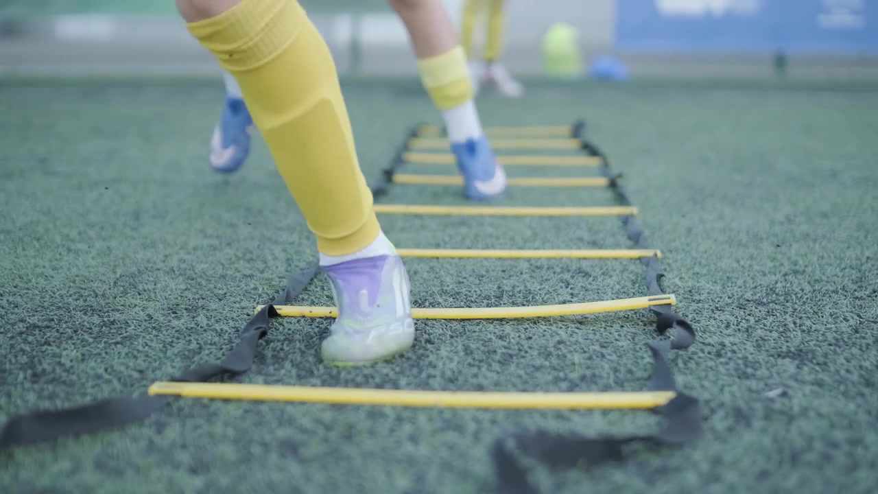 Unge fotballspillere som trener smidighetsøvelser på kunstgress