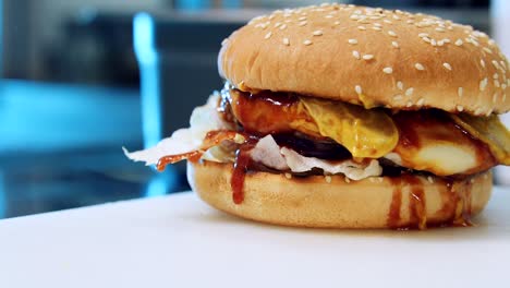 making hamburger. chef finishes cooking delicious burger. juicy burger with appetizing filling on the table. close-up