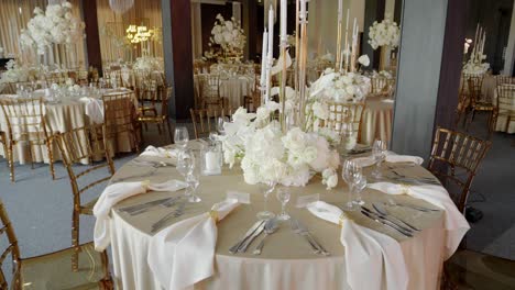 elegant wedding reception table setting with white flowers and gold accents