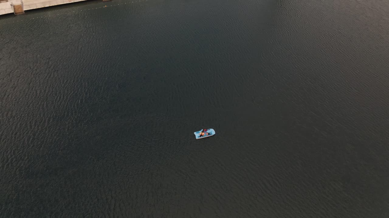 toma aérea de personas en un bote de remos en un lago verde