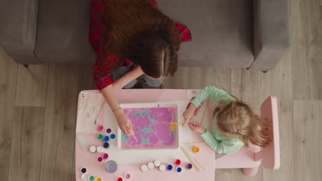 Woman-and-little-student-make-pattern-on-oily-water-surface