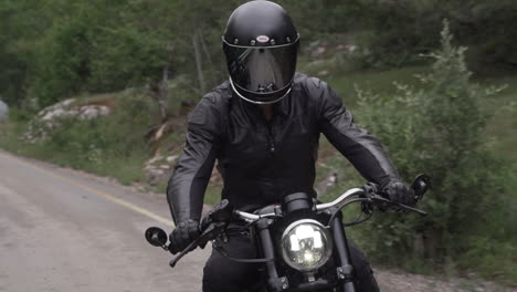 man riding a motorcycle on a mountain road