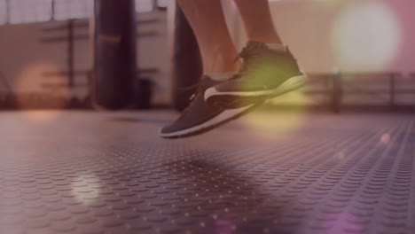 jumping feet in athletic shoes over bokeh lights animation in gym