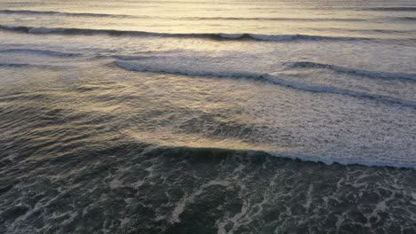 experience the raw power of the ocean as our drone captures the crashing waves below and pans up to reveal a breathtaking sunset on the horizon