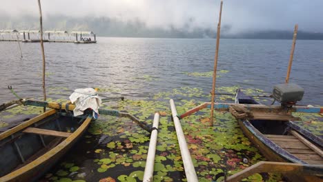 Barcos-Atracados-En-El-Lago-Beratan-Al-Atardecer-Por-Encima-De-Las-Nubes-Alrededor-De-Los-Lirios-De-Loto-Bali-Indonesia-Paisaje-De-Viajes