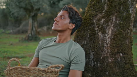 trabajador sonriente relajante noche naturaleza de cerca. hombre mirando hacia arriba oliva vertical