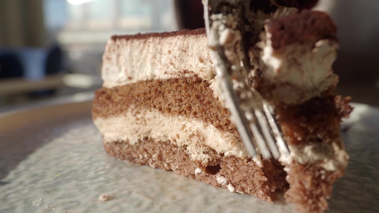 Close-up of a Fork Cutting into a Delicious Layered Cake