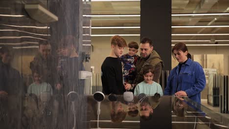 a family looking at a display of shower heads and tiles in a showroom