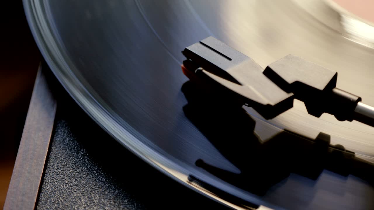 고대 비닐 레코드 플레이어를 사용하는 클로즈업. 턴테이블 플레이어, 비닐 레코드를 재생하는 데 스타일러스 바늘을 떨어뜨리는. 상단 뷰