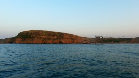 Slow-motion-at-Punta-Aderci-natural-reserve-and-trabocchi-seen-from-moving-boat-at-sunset