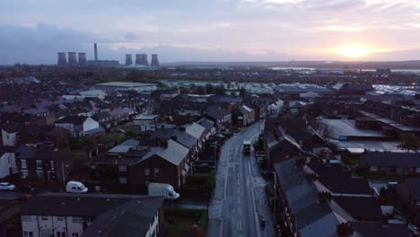 rainy industrial townhouse rooftops at sunrise with power station on horizon aerial view