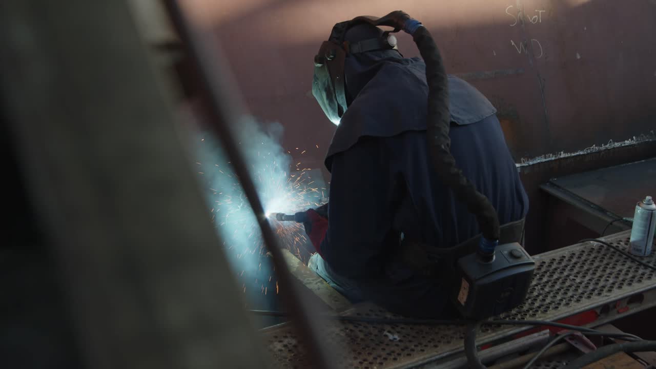 Man sitting in a cargo ship in shipyard