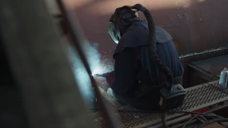 man sitting in a cargo ship in shipyard