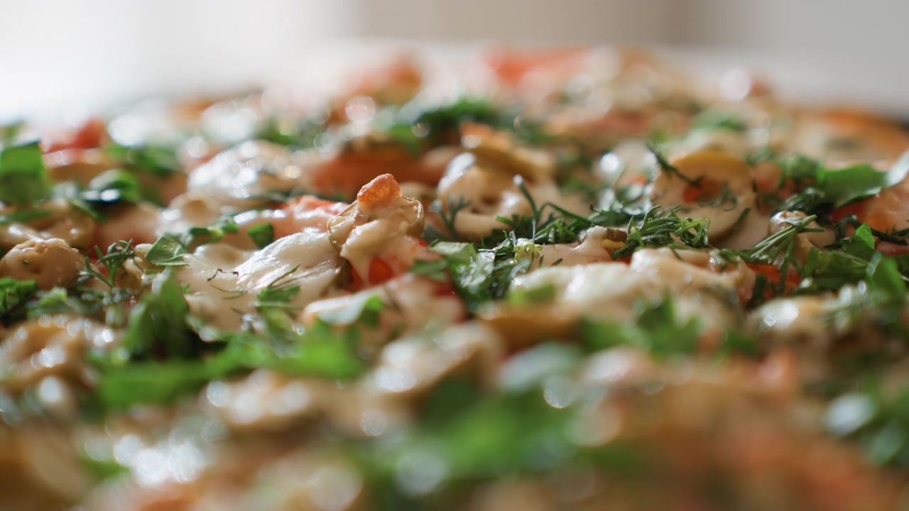 Low-angle close-up view of sizzling cooked dish with glossy bubbling sauce, fresh chopped herbs, warm steam and shallow focus, creating rich texture, appetizing color and vivid culinary appeal