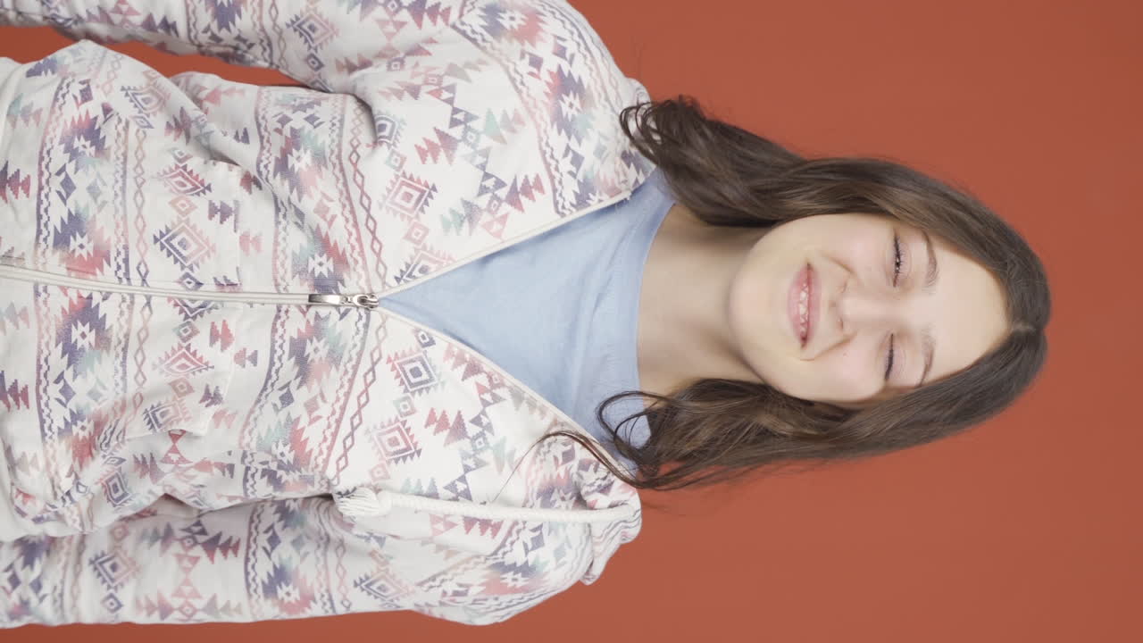 video vertical de una mujer joven mirando a la cámara haciendo un signo de confianza.