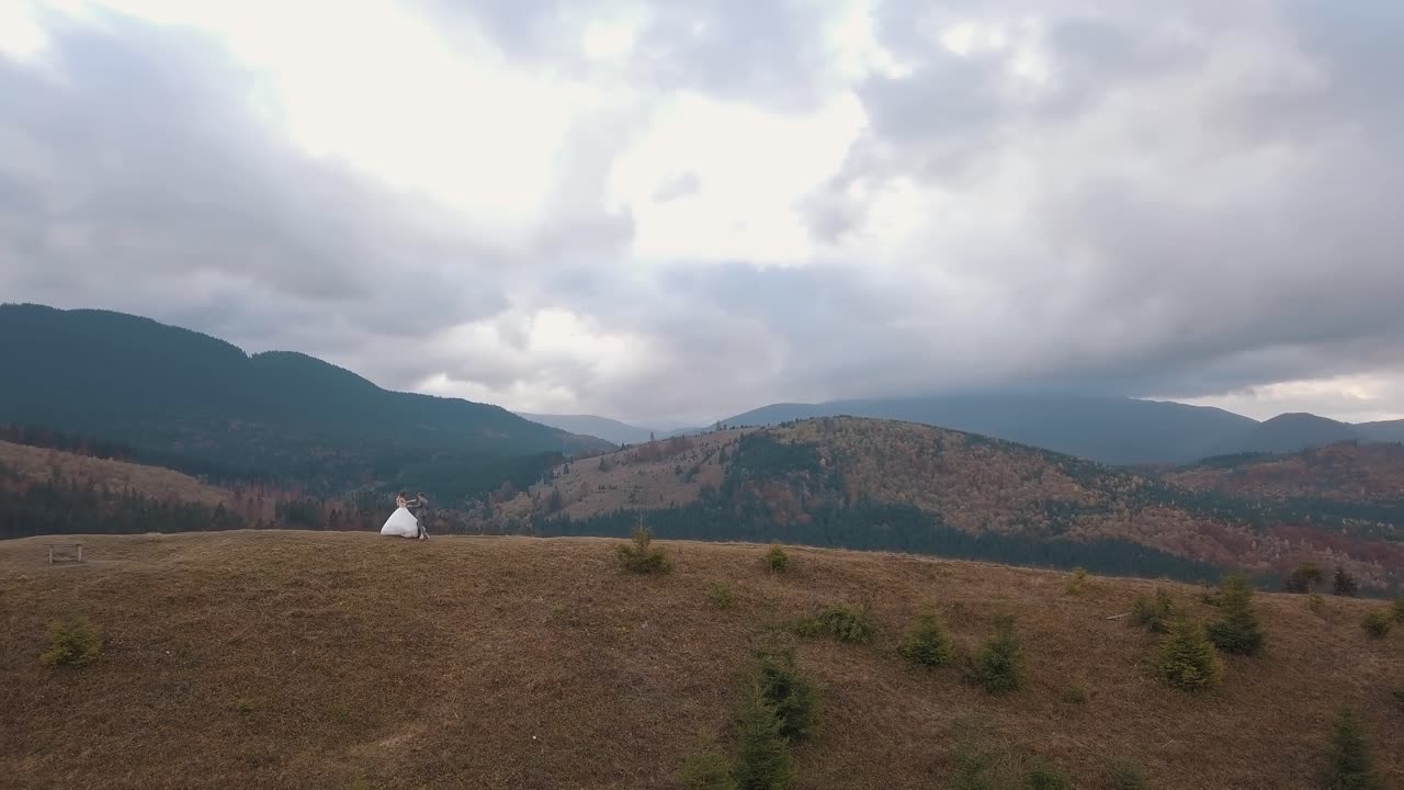 사랑스러운 신혼부부, 신부, 신랑이 산의 가을 경사에서 춤을 추는 공중 풍경, 결혼 부부, 가족