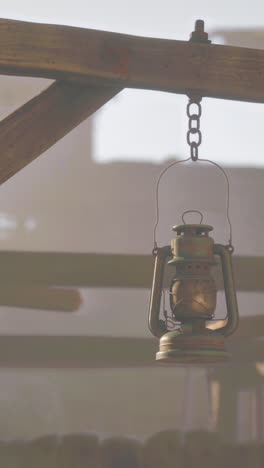 rusty hanging lantern on wooden beam