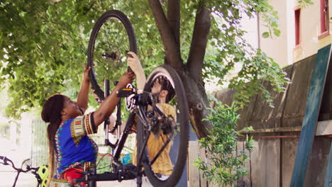 couple attaching fixed wheel to bicycle