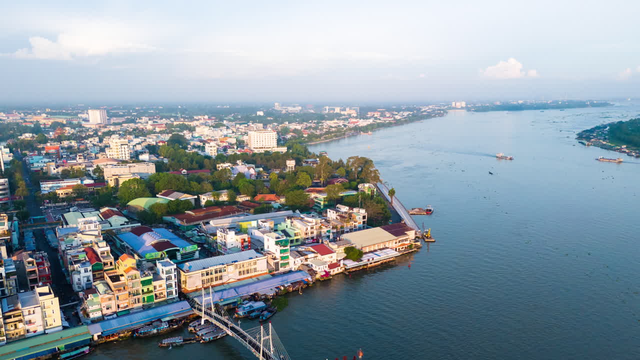 Trade vessels going about their business on the Mekong waterways, Vinh Long city, south Vietnam. Drone hyper lapse during early morning light.
