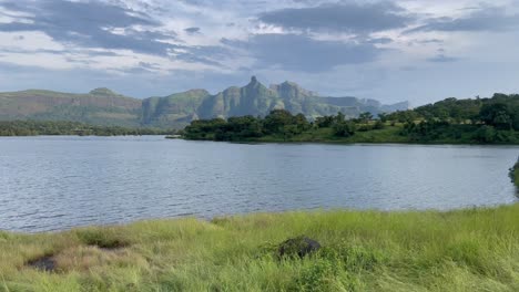 mar tranquilo con la cordillera de kalsubai al fondo en el santuario de vida silvestre de kalsubai-harishchandragad, ghats occidentales, maharashtra india