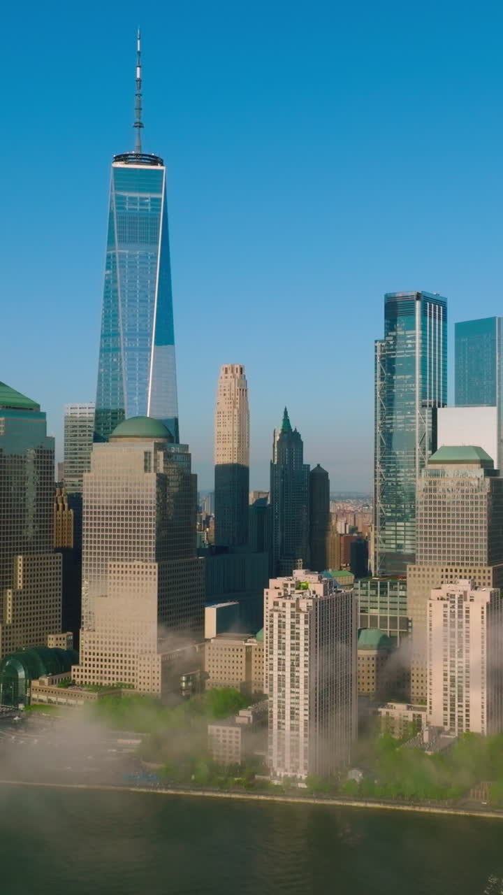 Outstanding New York skyscrapers at the backdrop of blue clear sky. White smoke coming up from the East river. Vertical video