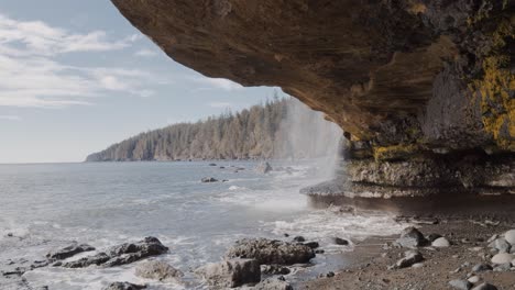 View-From-Cave-In-Juan-de-Fuca-Trail-With-Waterfall-Cascades-Straight-To-The-Ocean-In-Mystic-Beach,-Vancouver-Island,-BC,-Canada