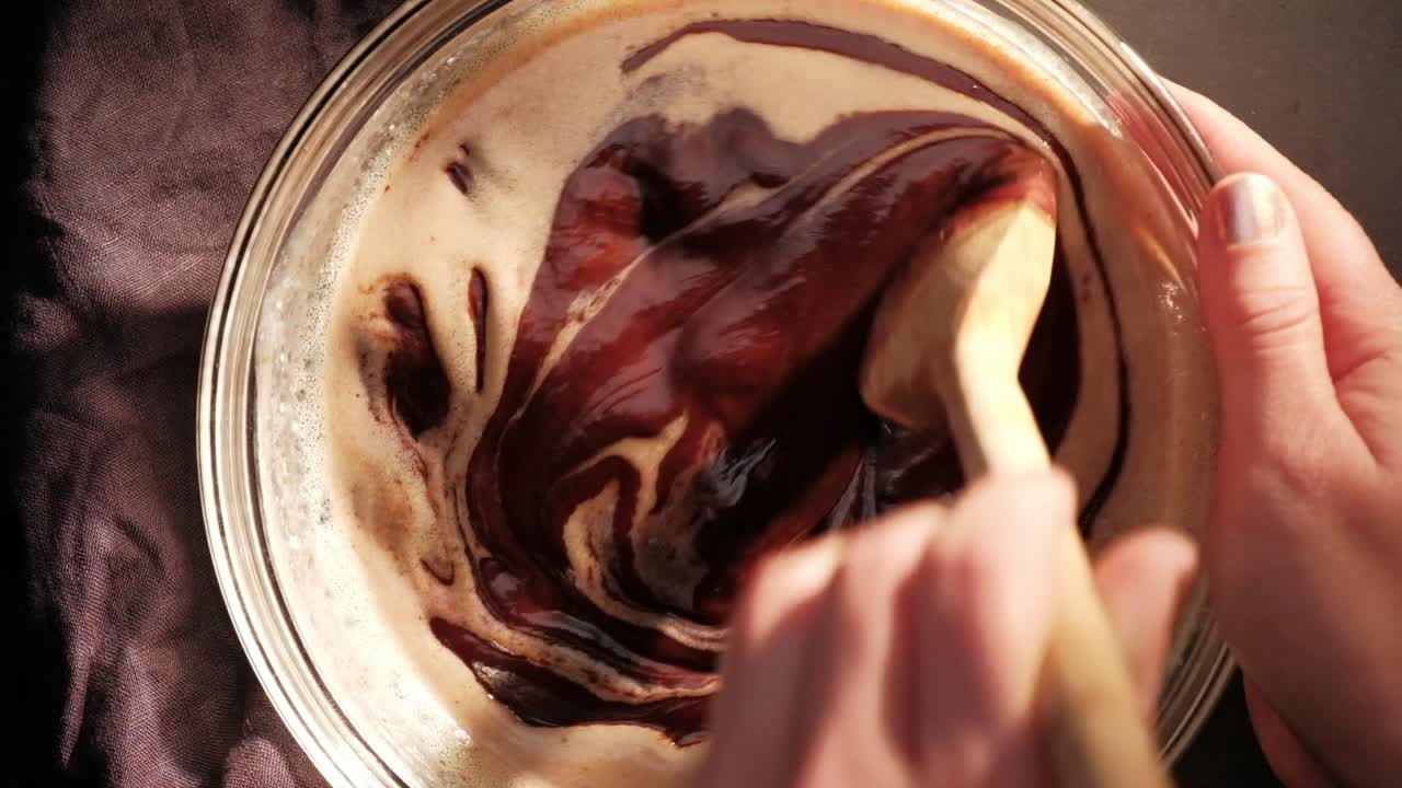 topview de remover gotas de chocolate, crema y mantequilla con cuchara de madera
