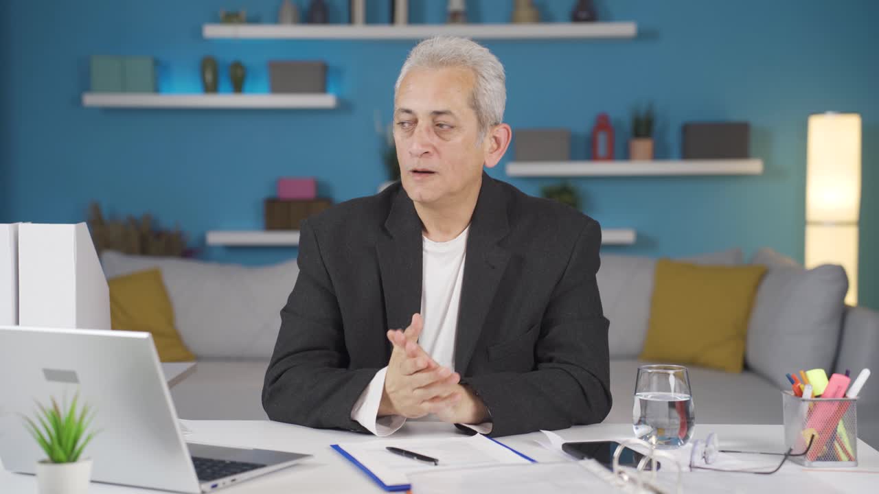 가정 사무직 노동자 남자는 흥분하고 행복한 느낌으로 카메라를 보고 있습니다.