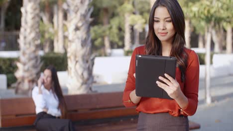 Young-businesswoman-using-a-tablet-outdoors