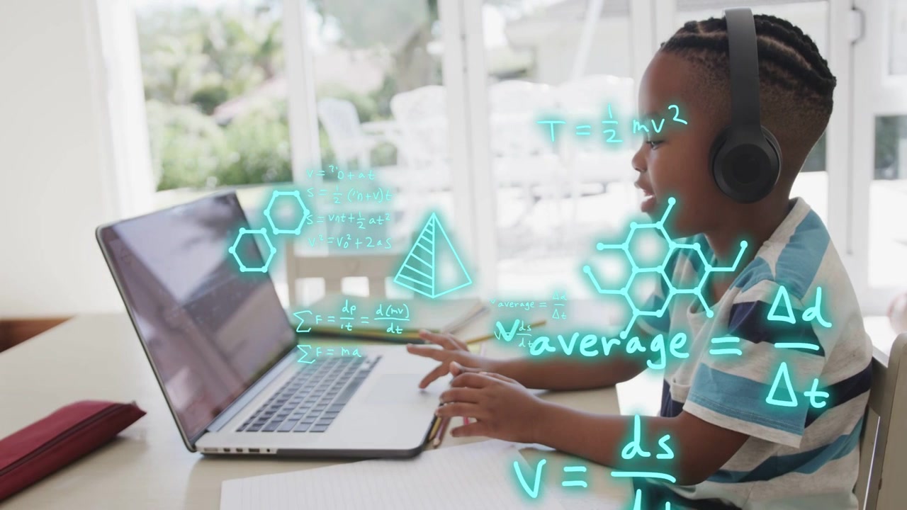 Boy sitting at laptop typing and speaking causing neon hexagons covering hands aiding learning