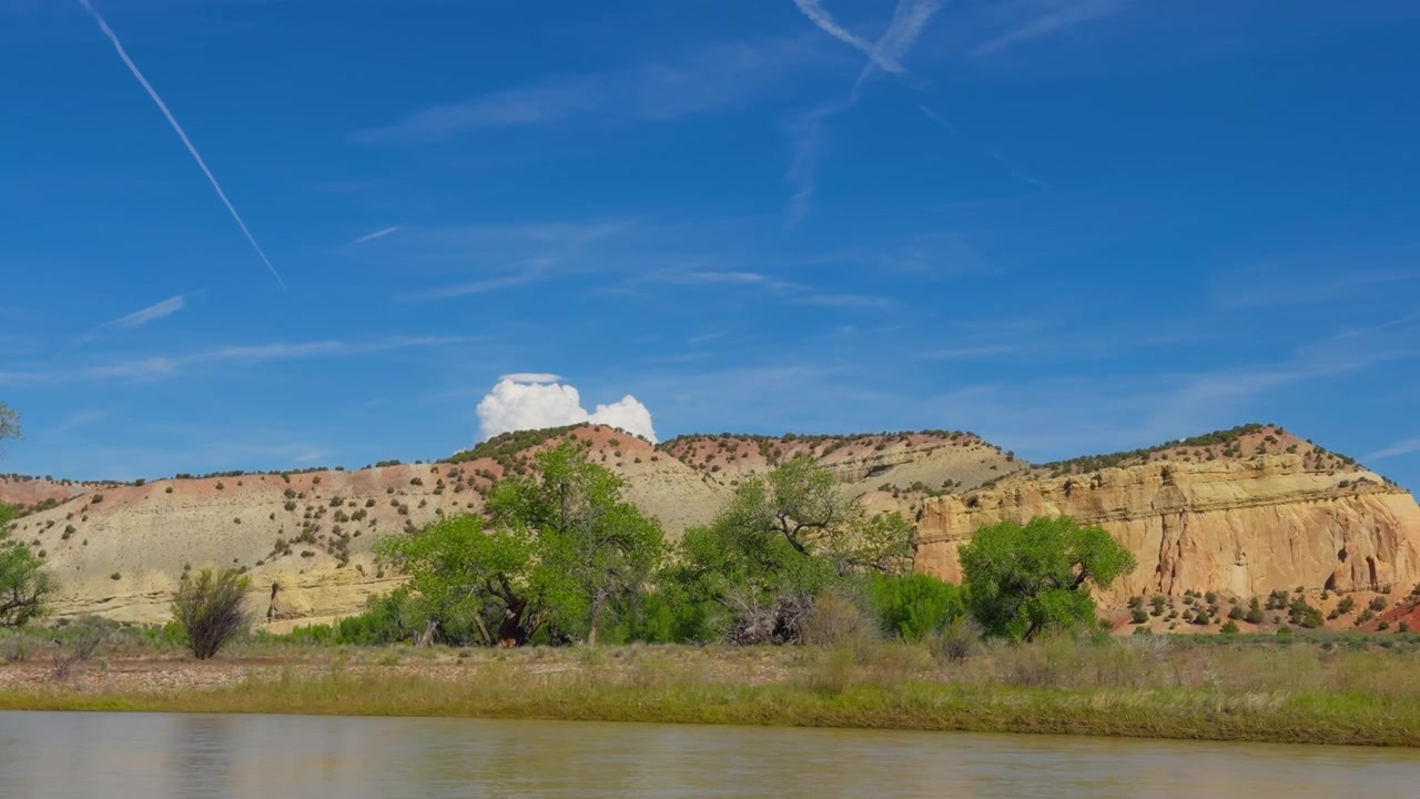 Layered sandstone cliffs and desert vegetation in Colorado, wide overview of Yampa River, backcountry pack rafting experience