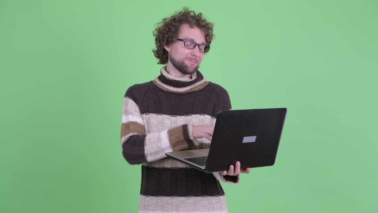 un joven guapo con barba y cabello rizado.