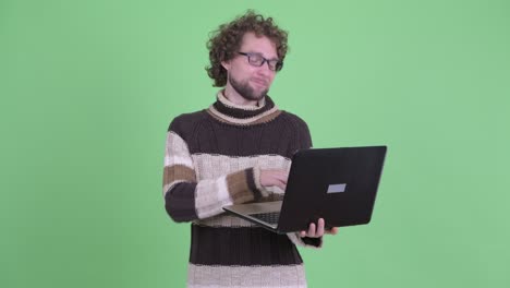 un joven guapo con barba y cabello rizado.