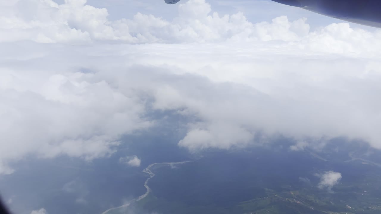 Footage of white clouds and sky in motion, captured from an airplane. Perfect for travel, aerial views, and nature projects, showcasing serene skies and dynamic movement above the landscape