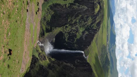 Beautiful-Maletsunyane-river-waterfall-into-deep-canyon,-cattle-graze