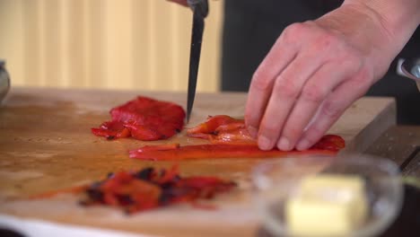 cuting roasted peppers using a knife and hands